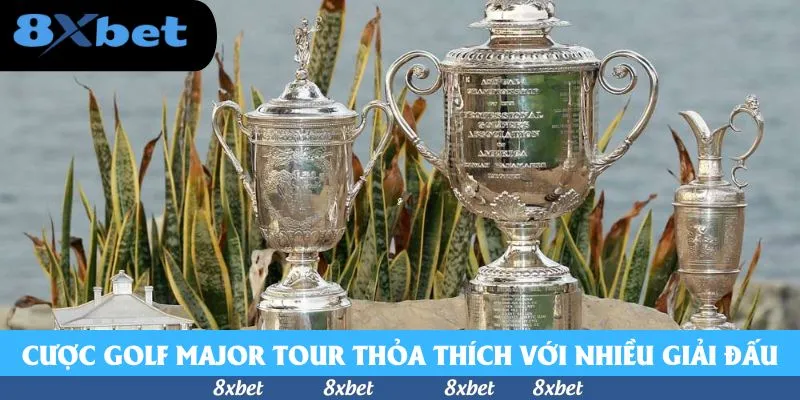 Cá cược golf Major với ba chiếc cúp bạc đặt cạnh nhau trước khóm cây lá đỏ xanh bên bờ nước