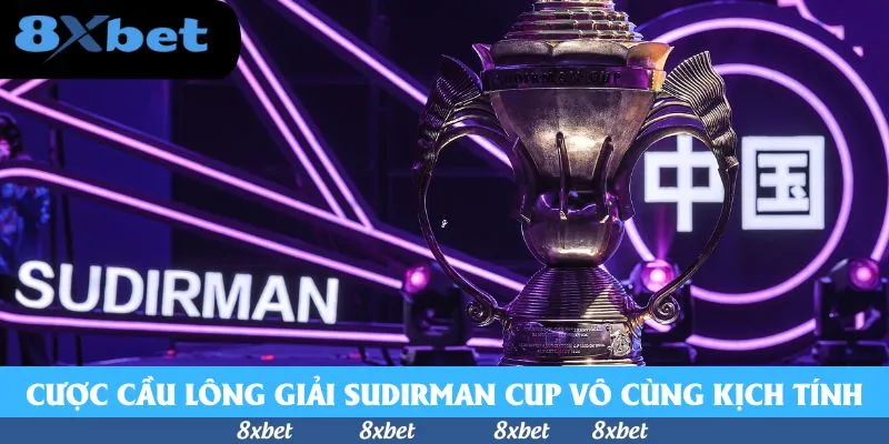 Cược cầu lông Sudirman Cup với chiếc cúp bạc trên sân khấu đèn tím và dòng chữ SUDIRMAN phía sau