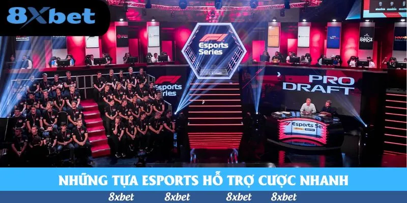 Sân khấu giải esports với các tuyển thủ mặc áo đen ngồi trên khán đài và bàn bình luận phía trước dưới ánh đèn đỏ