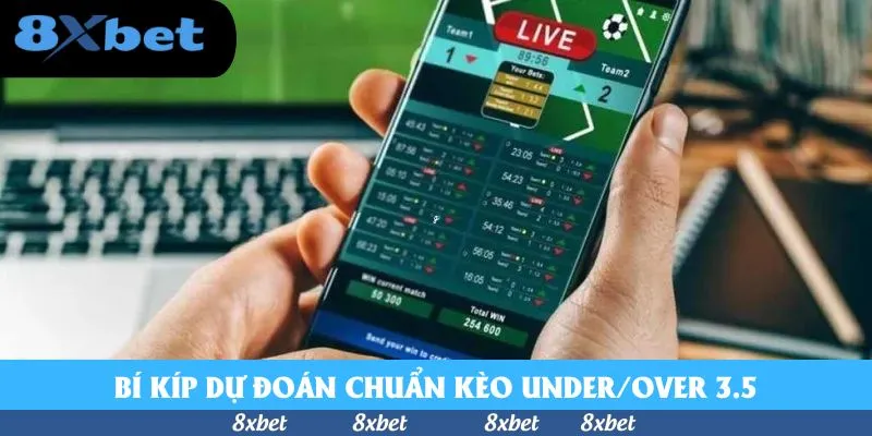 Tay cầm điện thoại hiển thị bảng kèo trực tiếp với tỷ số trận đấu đang diễn ra