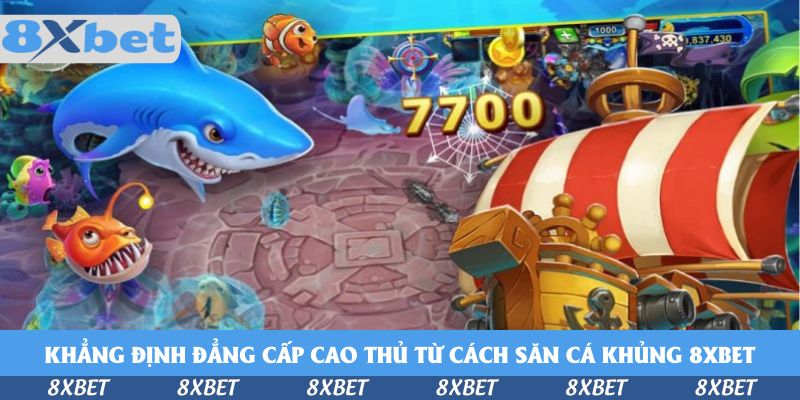 Thuyền buồm sọc đỏ trắng, cá mập xanh, cá lồng đèn và tâm ngắm trên màn hình bắn cá với con số 7700 nổi bật