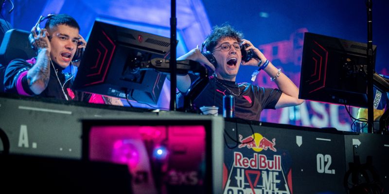 Hai tuyển thủ esports đeo tai nghe hét lên phấn khích trước màn hình thi đấu trên sân khấu